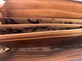 a person holding a purse with a lot of things inside of it