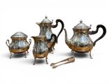 three pieces of silver tea and coffee set on a white surface