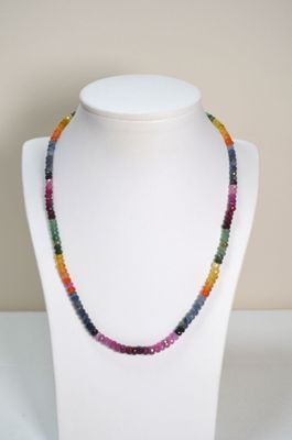 un gros plan d'un collier composé de perles multicolores porté par un mannequin