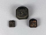 trois petits objets métalliques posés sur une surface blanche