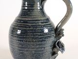 a blue vase with a handle on a white background