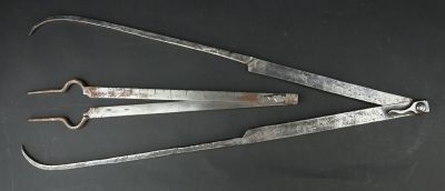Deux vieux outils en métal sont posés sur une surface noire.