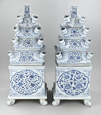 une paire de vases chinois bleus et blancs posés sur des socles, sur fond gris