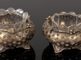 paire de bougeoirs en cristal posés sur une surface noire avec reflet
