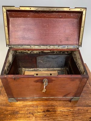 une vieille boîte en bois posée sur une table, avec une clé à l'intérieur