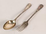 two spoons and a fork on a white surface