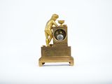 a small gold clock with a statue on top of it
