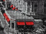 black and white photograph of a city street with red umbrellas