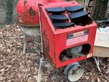 une machine rouge qui trône au milieu des feuilles