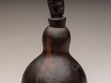 a close up of a small bottle with a face on it