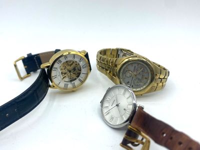 three watches are sitting next to each other on a white surface