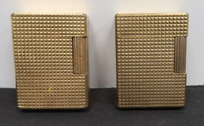 two gold lighters sitting next to each other on a table