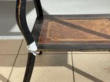 a small table with a wooden top on a tiled floor