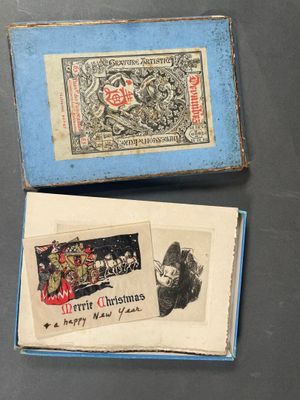 Deux petites boîtes ornées de timbres sont posées sur une table.