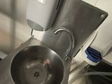 a stainless steel sink in a kitchen with a hand dryer