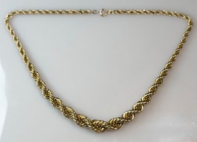 a close up of a gold necklace on a white surface