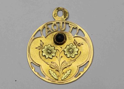 un gros plan d'un pendentif en or orné d'un motif floral