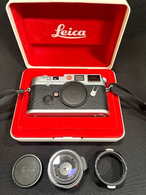 an old leica camera in a red case with a lens and other accessories