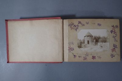an open book with a picture of a house in the background
