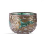 a green and brown bowl with a bird design on it