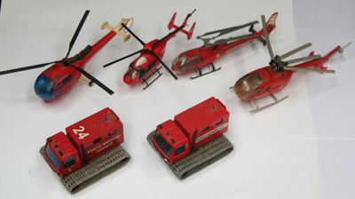 beaucoup de petits véhicules et un hélicoptère posés sur une table