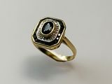an image of a gold ring with a black and white stone
