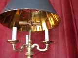 une lampe posée sur une table, avec un rideau rouge en arrière-plan