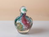 a small glass bottle with a small figurine inside of it
