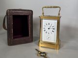 une petite horloge posée à côté d'une clé dans une boîte