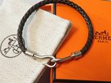 une boîte orange avec un bracelet en cuir noir et un fermoir en argent