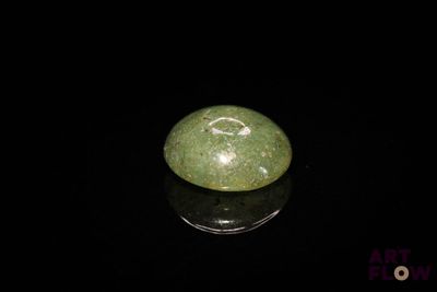 une image représentant une boule de jade verte posée sur une surface noire