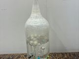 a glass bottle with a picture inside of it on a table