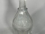 a clear glass bottle with a small glass stopper on it