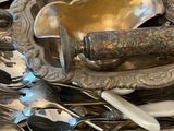 a pile of silver spoons and spoons on a table