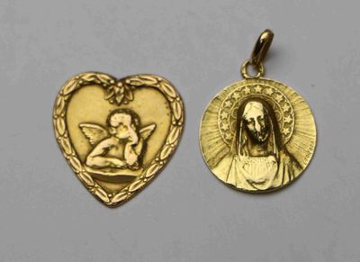 un gros plan sur deux pendentifs dorés en forme de cœur posés sur une surface blanche