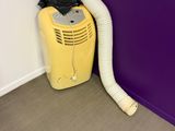 a yellow blow dryer sitting next to a purple wall