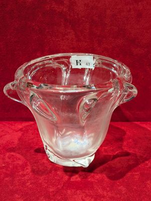 un gros plan d'un vase en verre posé sur une surface rouge