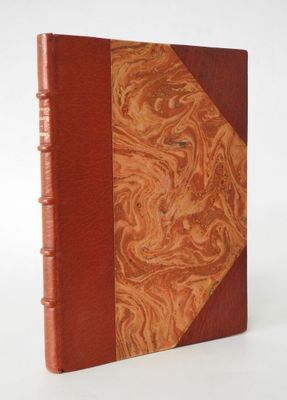 an old book with a red cover and a brown leather cover