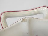 a close up of a white vase with red trim