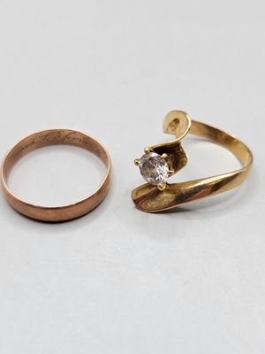 deux bagues en or et une bague en diamant posées sur une surface blanche