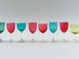 six wine glasses lined up in a row on a table