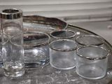 a silver tray with glasses and a bottle on it