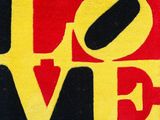un gros plan sur un tapis rouge, jaune et noir sur lequel figure le mot « love »