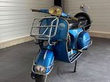 a blue scooter that is parked in a garage