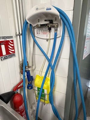 un tuyau bleu fixé au mur d'une salle de bains