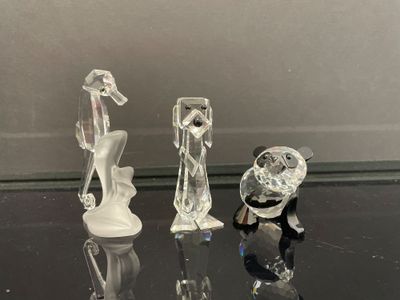 trois figurines posées sur une table en verre