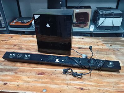 a wooden table with a remote control and a speaker on it