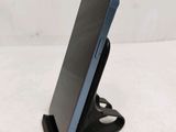 a close up of a cell phone on a stand on a white surface