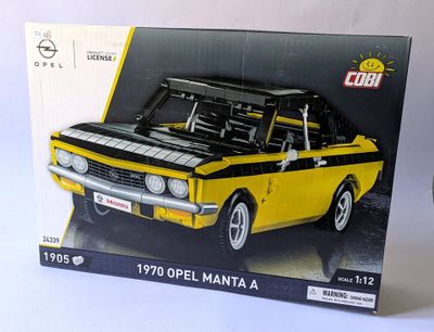 modèle jaune et noir d'une voiture dans une boîte sur une surface blanche