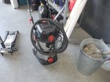 un seau de terre à côté d'une machine dans un garage